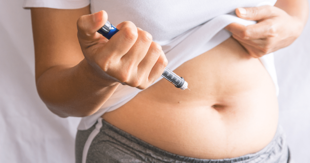 woman pointing a type of needle towards her stomach